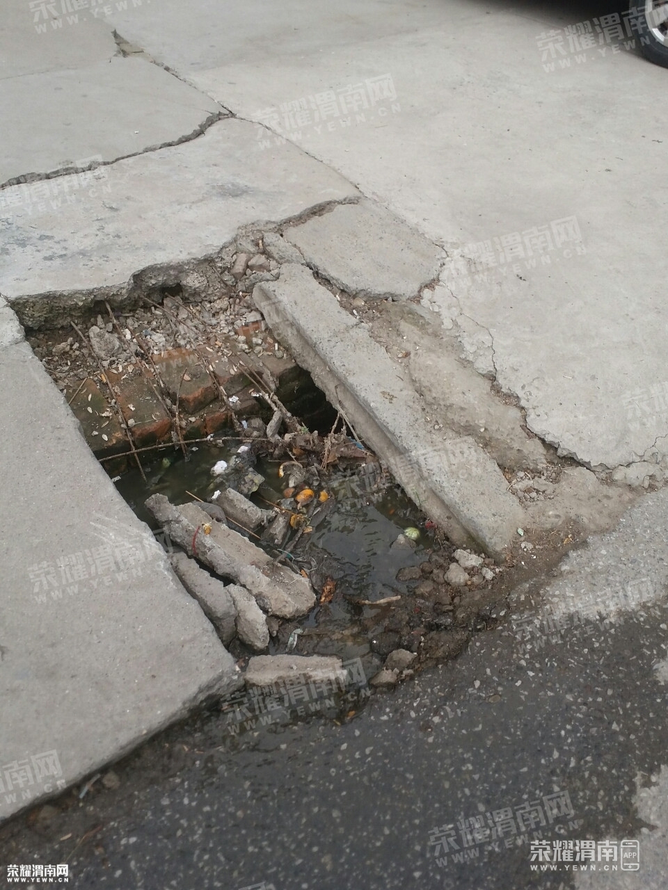 渭花路秦牛社区路边下水道堵塞,污水横流,路面也有所损坏.