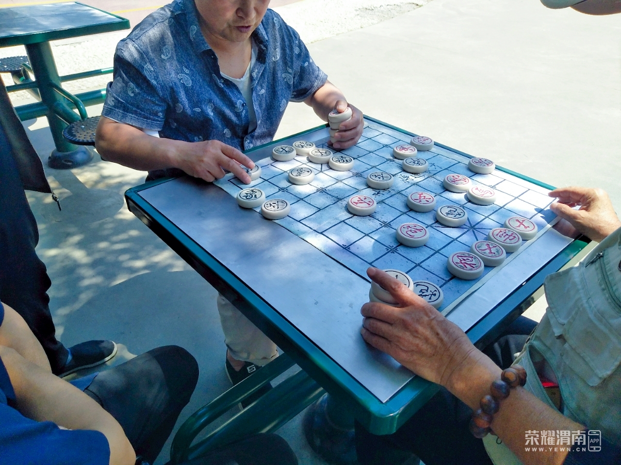 信达运动场上有几位老大爷正在下象棋,炎炎夏日也挡不住他们的热情