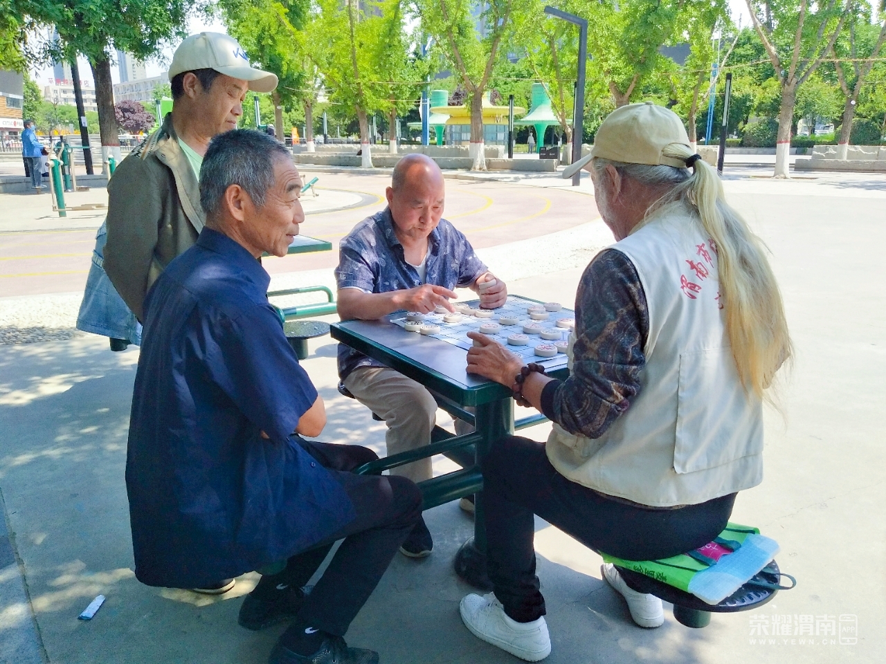 信达运动场上有几位老大爷正在下象棋,炎炎夏日也挡不住他们的热情
