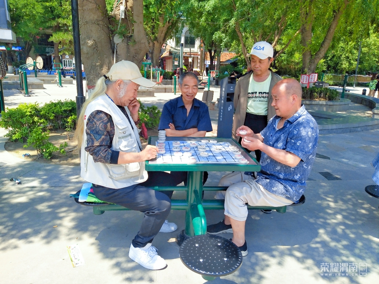 信达运动场上有几位老大爷正在下象棋,炎炎夏日也挡不住他们的热情